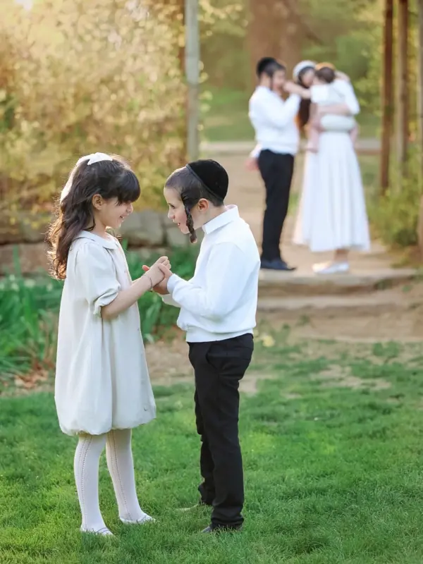 Brother and sister holding hands, parents behind them, outdoor photography by Photoholic, Rockland County NY