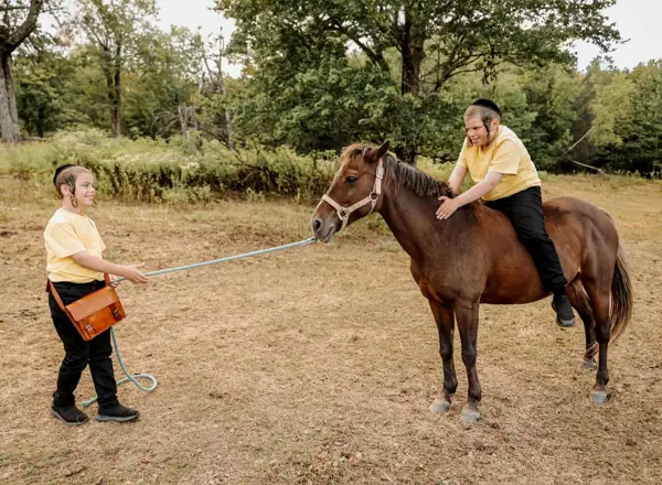 Girl leading a pony with her brother riding, outdoor photography by Photoholic, Rockland County NY
